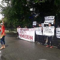 裁判所の決定後、「学生の声を消すな」「国は表現の自由を保障していない」などと書かれた横断幕を掲げて抗議する学生ら=国立北スマトラ大学周辺で、ヤエル・シナガさん提供