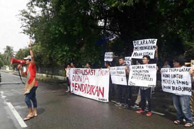 裁判所の決定後、「学生の声を消すな」「国は表現の自由を保障していない」などと書かれた横断幕を掲げて抗議する学生ら＝国立北スマトラ大学周辺で、ヤエル・シナガさん提供