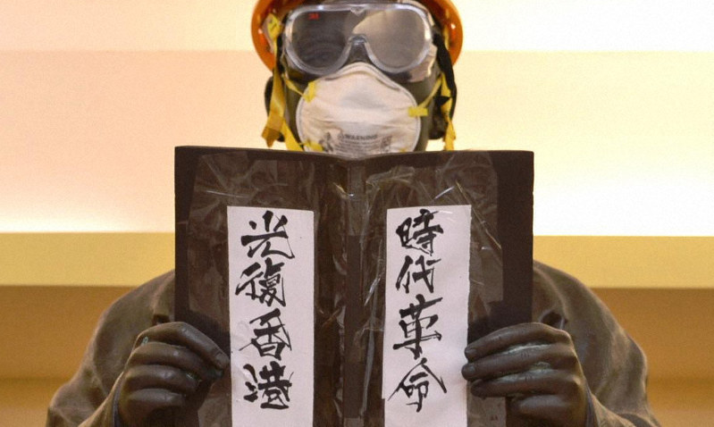 ヘルメットやゴーグル、マスクを付けられた孫文像。「時代革命」(革命の時だ)「光復香港」(香港を取り戻せ)のスローガンも張られていた=2019年11月29日、福岡静哉撮影