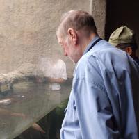 山口県宇部市のときわ動物園でカワウソを見るニコルさん=C.W.ニコル・アファンの森財団提供