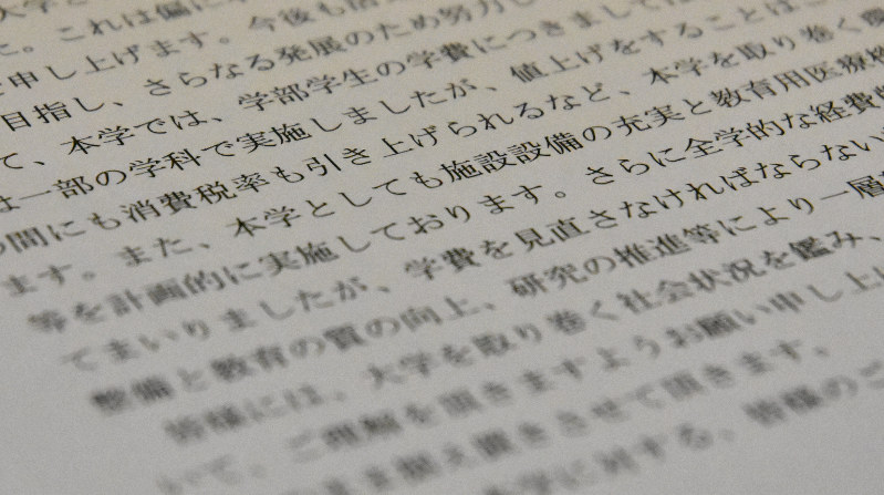 来年度の入学者から学費を値上げする私立大が作成したお知らせ文。背景の一つとして、消費税の引き上げによる経営環境の悪化が挙げられている=2019年10月11日、大久保昂撮影