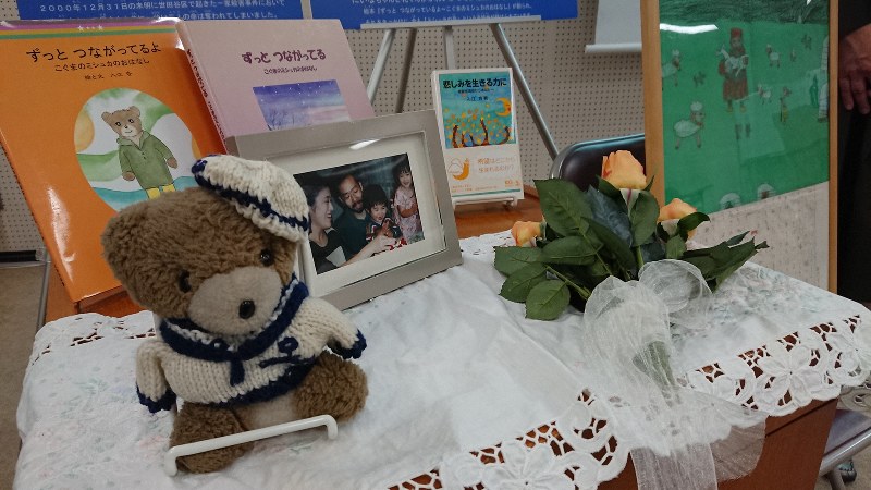 集い「ミシュカの森」に展示されていたぬいぐるみのミシュカ(左)や被害者一家の家族写真=東京都内で7日、小国綾子撮影
