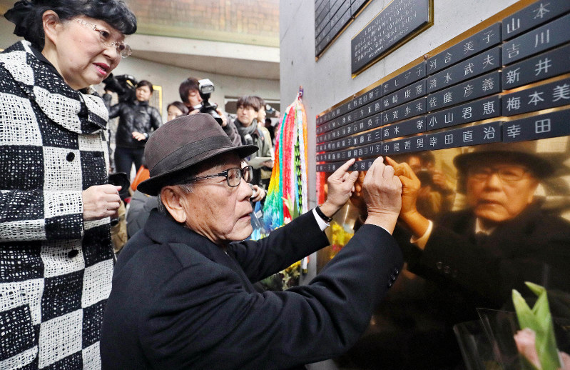 弟の幸司さんの名前が刻まれた銘板を設置する今村憲司さん(中央)=神戸市中央区で2019年12月14日午後2時12分、幾島健太郎撮影