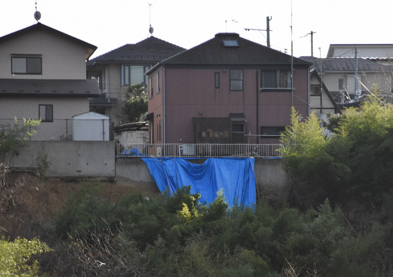 台風の影響で一部が崩れ、ブルーシートがかけられた高台ののり面。その上に建つ住宅の3世帯には、今も避難指示が出されている=宮城県大河原町で2019年12月12日午後2時21分、藤田花撮影