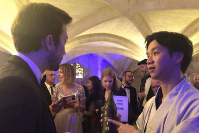 品評会で参加者に「だいやめ」を勧める浜田酒造の浜田光太郎さん（右）＝ロンドンで