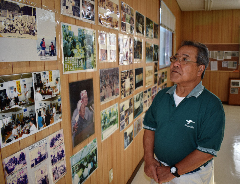 閉店した金物店の壁に辺野古区民の反対運動の写真を張った西川征夫さん=沖縄県名護市辺野古で2019年12月10日、平川昌範撮影