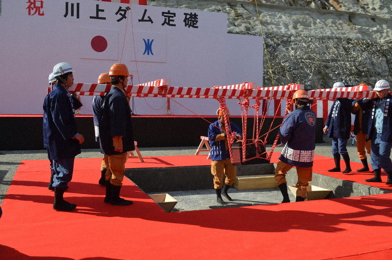 紅白のロープでつるされ、埋める場所に搬入された礎石=三重県伊賀市で、大西康裕撮影
