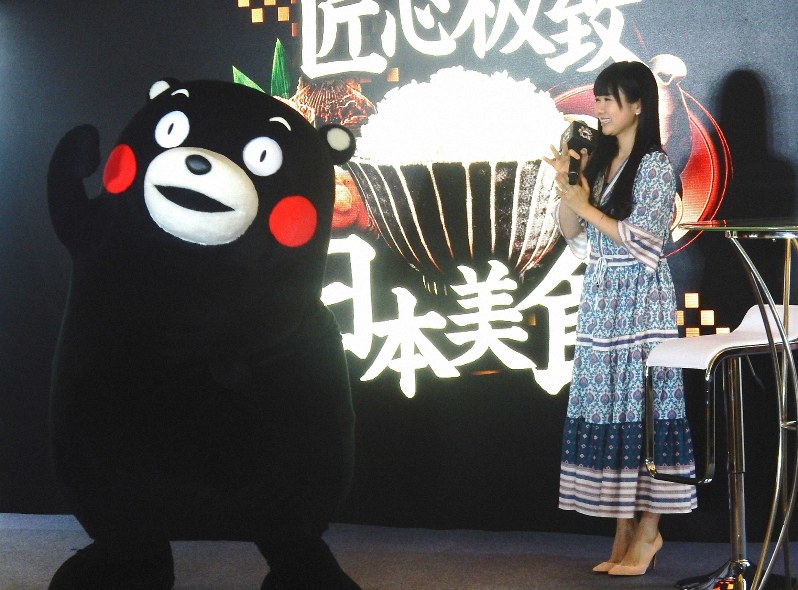 日本料理の魅力をPRするイベントに参加した福原愛さんとくまモン=北京市内のホテルで12月9日、赤間清広撮影