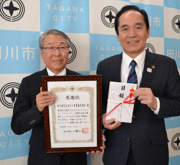 田川市役所で二場市長(右)から寄付への感謝状を受け取った橋本専務理事