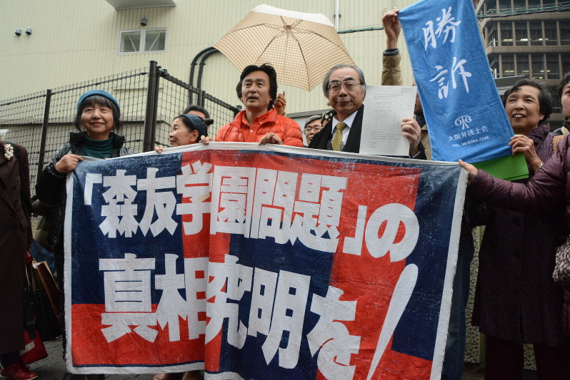 判決後、大阪高裁前で喜びを見せる木村真・大阪府豊中市議(中央)ら=大阪市北区で2019年12月17日午後1時31分、山本康介撮影