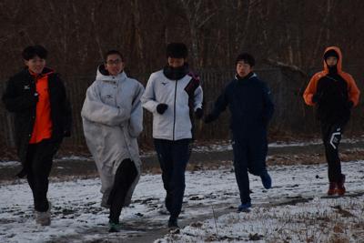 学校のグラウンドを走る北海道栄の選手たち＝北海道白老町で