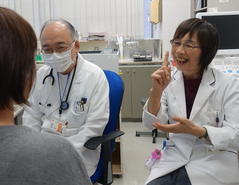 医師の話を患者に手話で伝える通訳の浜野亮子さん(右)=市立札幌病院提供