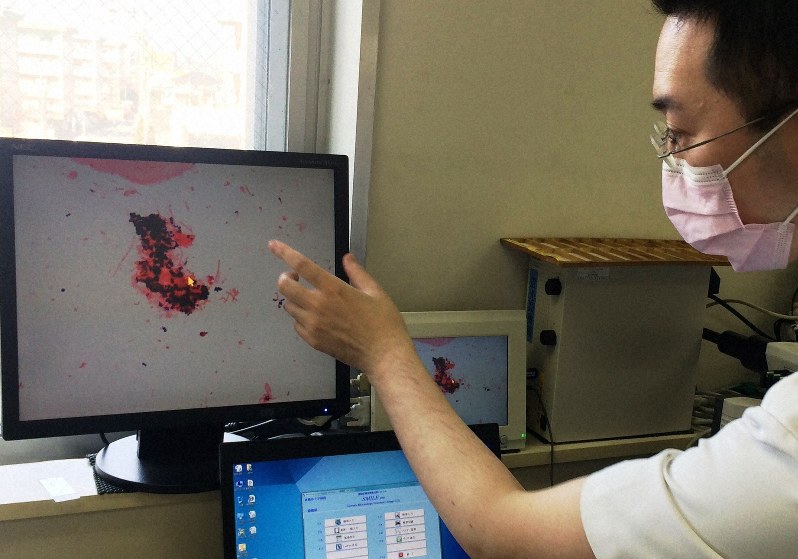 顕微鏡による細菌検査の結果を、画面で確認する医師
