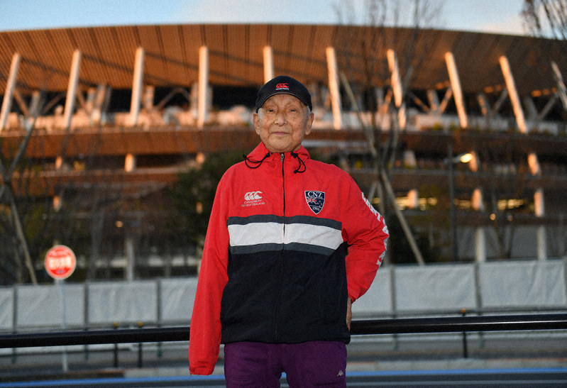完成したばかりの国立競技場の前に立つ菊池浩一さん=東京都新宿区で2019年12月23日、宮間俊樹撮影