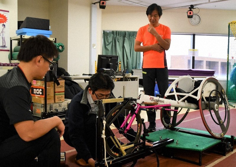 スポーツ用車椅子を使った3次元動作解析の準備をする、県立医科大学げんき開発研究所の指宿立副所長(右)ら=和歌山市本町2の同研究所で、黒川晋史撮影