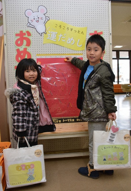 本の福袋を手に、「運だめしゲーム」を楽しむ子どもたち=今治市大西町宮脇で、松倉展人撮影