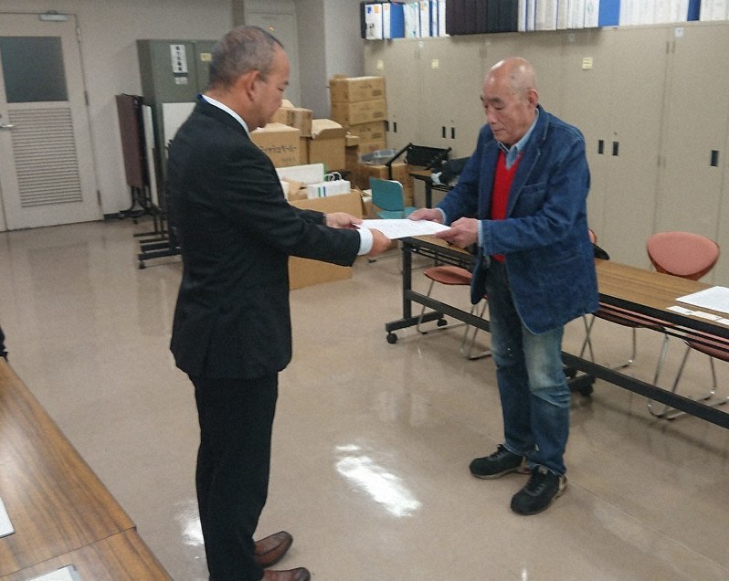 要請書を県の担当者(左)に手渡す「瀬戸石ダムを撤去する会」の出水晃・共同代表