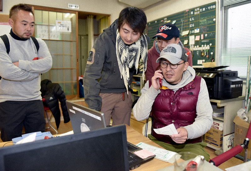 ボランティアの手配をする鈴木隆太さん(右)=佐賀県武雄市北方町で2019年12月22日、田鍋公也撮影