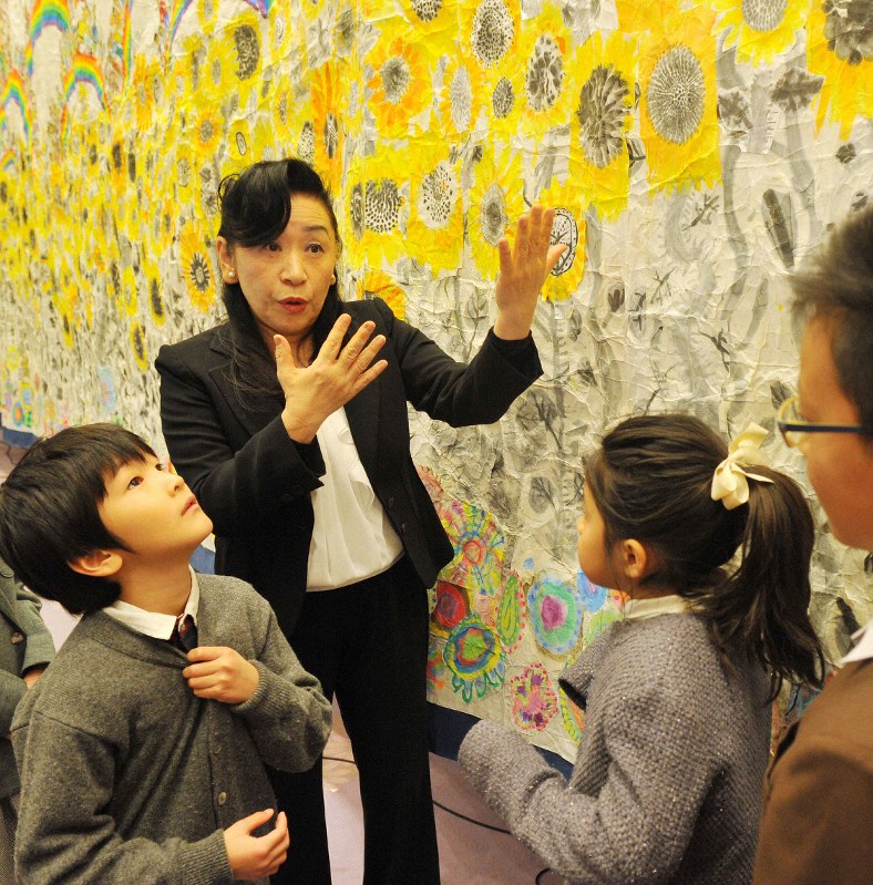 阪神大震災の犠牲者を思い、教室の生徒が描いた巨大な絵を前に、子供たちに命の尊さを語る中嶋洋子さん(中央)=神戸市中央区で2015年1月11日午後4時13分、梅田麻衣子撮影