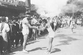 旧里美村(現・常陸太田市)で1964年に行われた手作りの聖火リレー。多くの人が沿道で声援を送った=茨城県里美村教育委員会「ふるさと写真帖ー里美の今昔ー」より