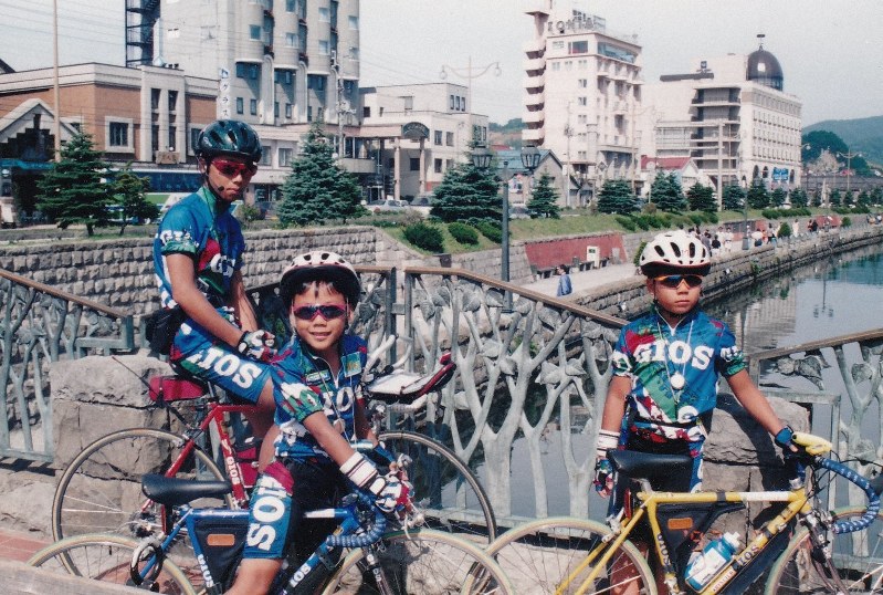自転車で日本一周をして募金活動をする矢崎正道さん(右)と直道さん(中央)=北海道小樽市で1997年8月15日、母親の矢崎由美子さん提供