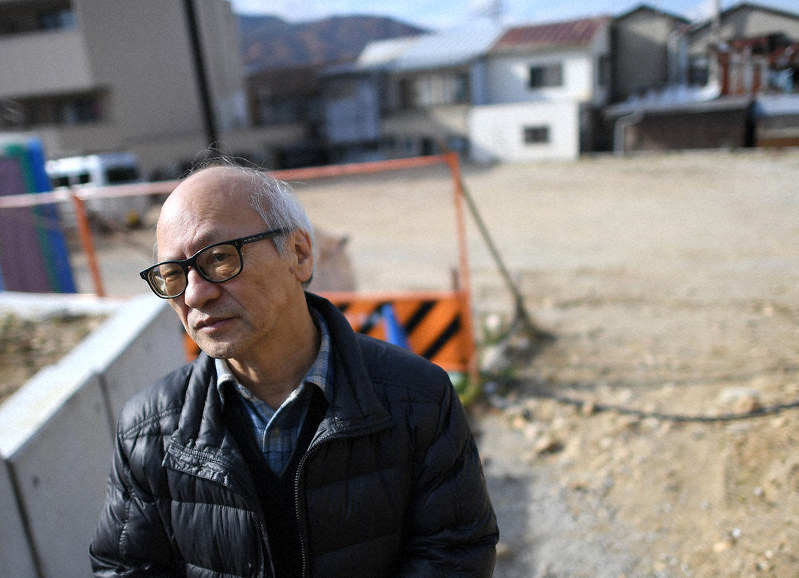 船越隆文さんが亡くなったアパートの跡地(奥)を訪れ、当時を振り返る将棋の森信雄七段=兵庫県宝塚市で、久保玲撮影