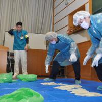 汚染物の除去訓練をする参加者＝京都市上京区の府立医大で、小田中大撮影