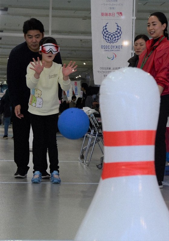 ゴールボールの体験ブースで姶目隠しをした状態で拍手の音を頼りにボールを投げる女の子=江東区青海1のメガウェブで