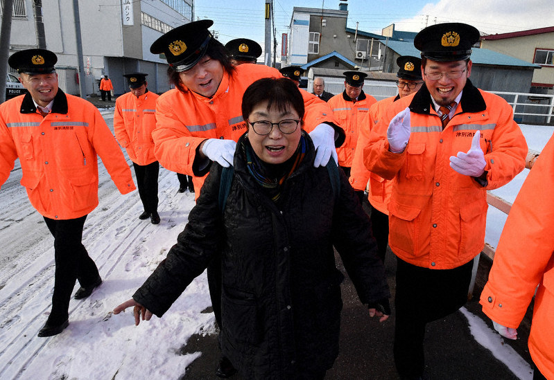 消防出初め式の取材に訪れた相沢さんの周りに団員たちが集まる。「自分にとって町の若い人たちは子供や孫、お年寄りは親だと思っている」=北海道津別町で