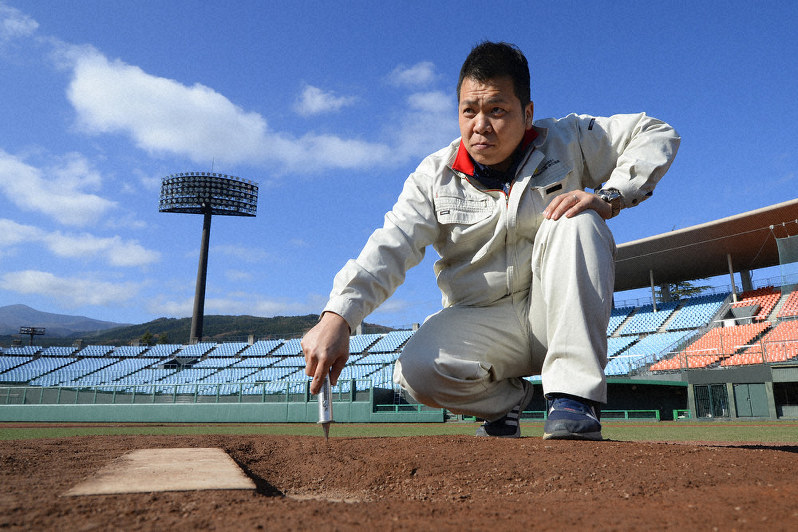 硬度計を手にマウンドの硬さを確かめる高橋政人さん=福島市佐原の県営あづま球場で