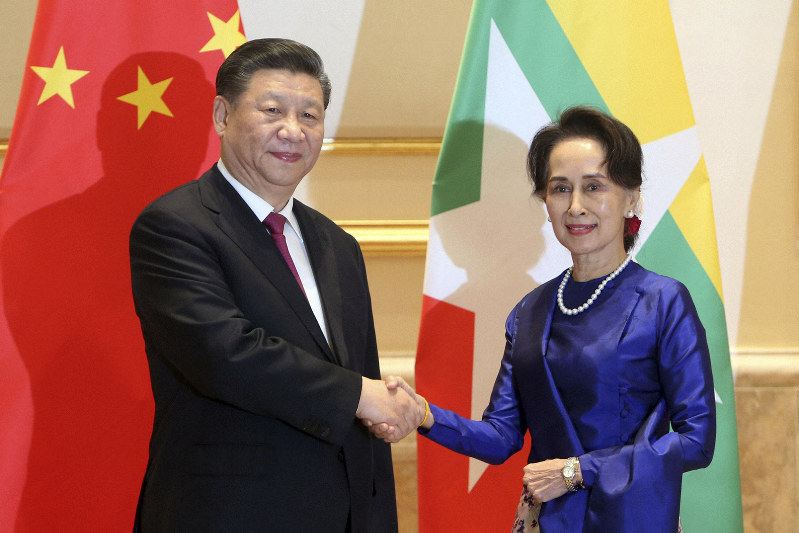 習近平国家主席(左)と握手するアウンサンスーチー国家顧問兼外相=ネピドーで17日、AP