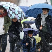 雪が降る中、センター試験の会場に向かう受験生ら＝東京都八王子市で2020年1月18日午前9時36分、佐々木順一撮影