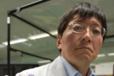 遺伝子解析に利用されるチップを示す東芝の担当者＝仙台市で、柳楽未来撮影