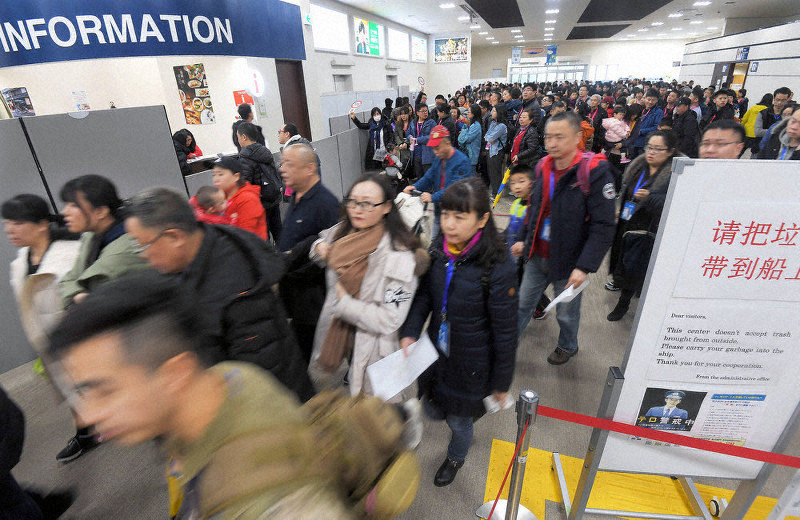 クルーズ船からの入国手続きを終え、待機するバスに向かう中国からの観光客ら=福岡市博多区で2020年1月22日午後2時58分、津村豊和撮影