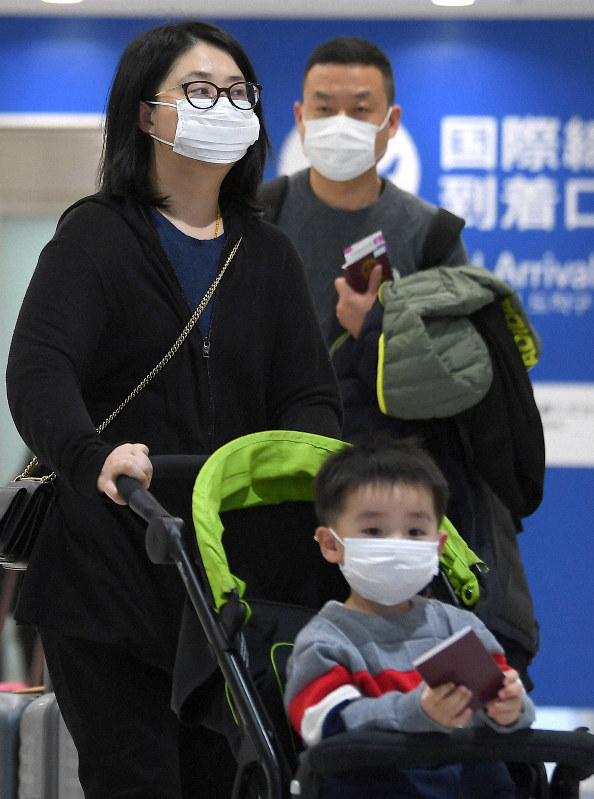 マスク姿で移動する中国からの乗客=関西国際空港で2020年1月24日午前10時11分、久保玲撮影