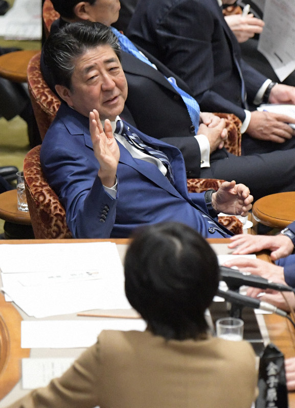参院予算委員会で「桜を見る会」を巡る問題についての自らの答弁で質疑が止まり、委員長席に集まる与野党の議員たちに発言する安倍晋三首相(奥)=国会内で2020年1月29日午前9時24分、川田雅浩撮影