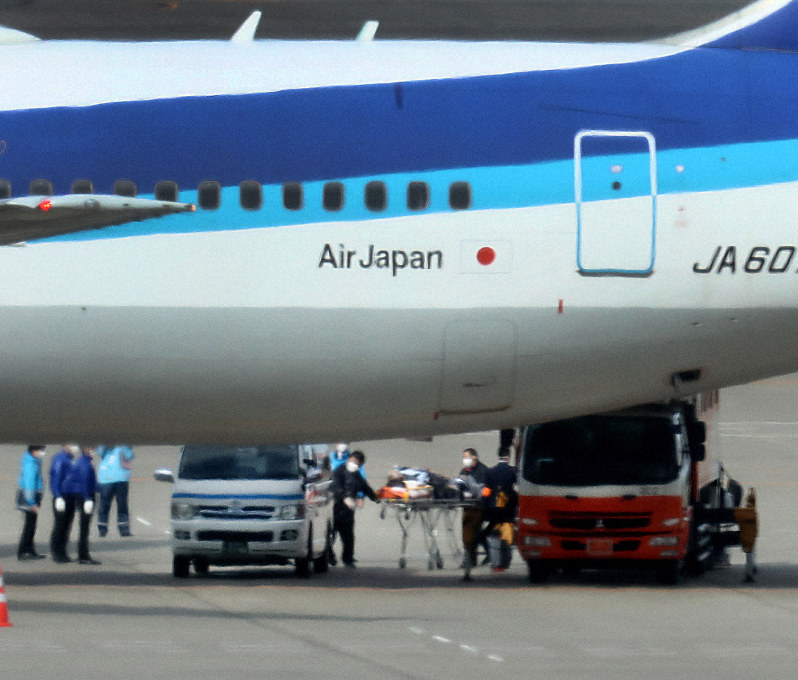 中国・武漢から到着したチャーター機の第3便から、ストレッチャーに乗せられ救急車両に搬送される乗客(中央下)=羽田空港で2020年1月31日午後0時6分、吉田航太撮影