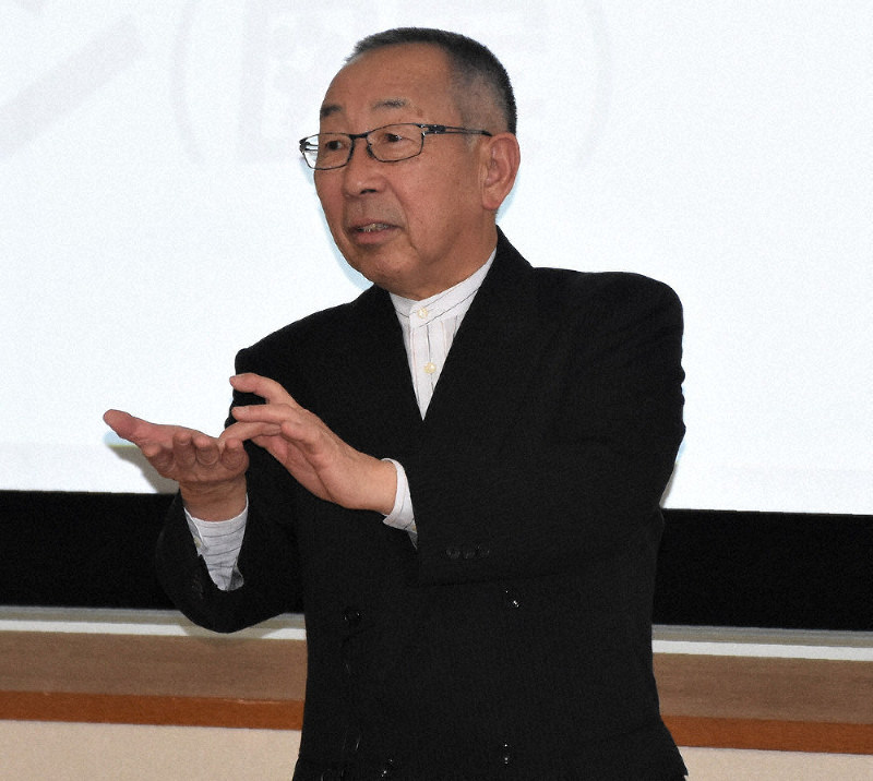 手話を交えながら講演する全通研の小出新一参与=鳥取市のとりぎん文化会館で、野原寛史撮影