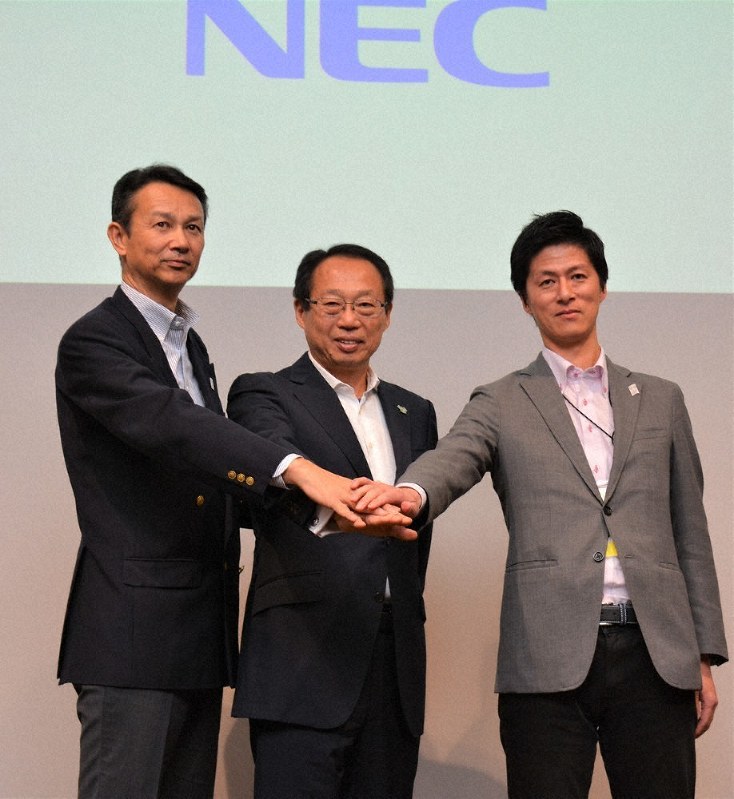 岡田武史氏を囲み、メソッドのICT化に自信を示すNECの中山啓二主席主幹(左)と大塚洋平・東京五輪・パラリンピック推進本部マネージャー=今治市にぎわい広場で、松倉展人撮影