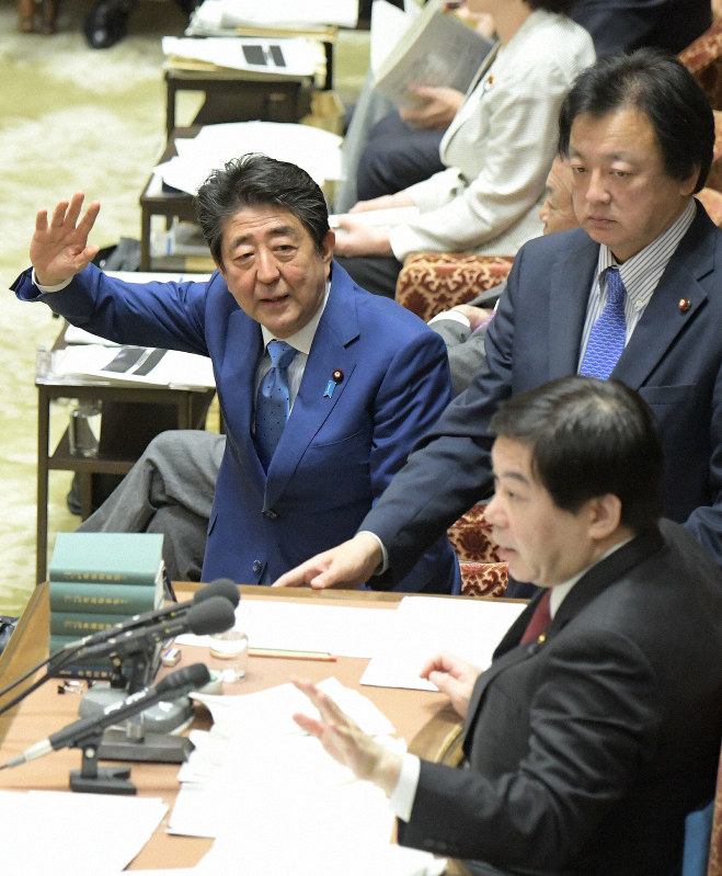 衆院予算委員会で「桜を見る会」とその前夜祭を巡る問題について立憲・黒岩宇洋氏の質問中に質疑が止まり、野党議員と協議する棚橋泰文委員長(右手前)に向かって挙手する安倍晋三首相(奥)=国会内で2020年2月4日午前9時57分、川田雅浩撮影