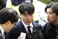 In this March 14, 2019, file photo, Seungri, center, member of a popular K-pop boy band Big Bang, arrives at the Seoul Metropolitan Police Agency in Seoul, South Korea. (AP Photo/Ahn Young-joon)