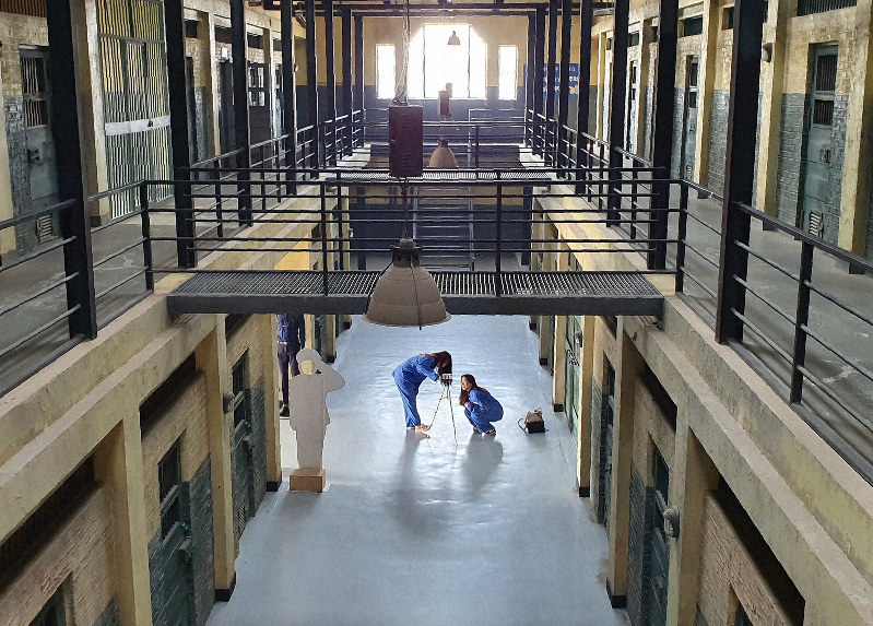 益山刑務所セット場で、囚人服を着て、自分たちの姿を撮影する若い女性=2020年1月18日、坂口裕彦撮影