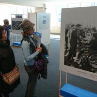 １９６４年東京パラリンピックの開会式写真に見入る見学者たち＝渋谷区宇田川町の渋谷区役所で