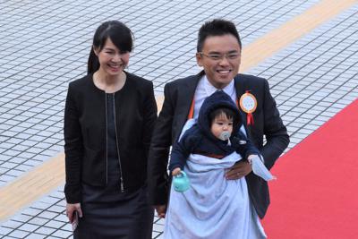 赤ちゃんを胸に抱き、妻と共に赤じゅうたんの上を歩く国民党の洪孟楷氏＝台北市の立法院で2020年2月1日、福岡静哉撮影