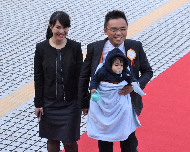 赤ちゃんを胸に抱き、妻と共に赤じゅうたんの上を歩く国民党の洪孟楷氏=台北市の立法院で2020年2月1日、福岡静哉撮影