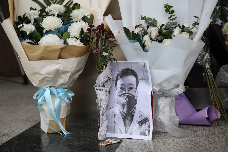 新型肺炎で死亡した李文亮医師が勤務していた病院のロビーに飾られた遺影と花束=中国武漢市で7日、ロイター
