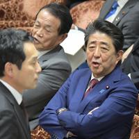 衆院予算委員会で質問を終えた立憲民主党の辻元清美幹事長代行に対する閣僚席からの自身の発言で審議が中断し混乱する中、棚橋泰文委員長に抗議する野党議員（手前）に声をかける安倍晋三首相（奥右）＝国会内で２０２０年２月１２日午後２時５７分、川田雅浩撮影