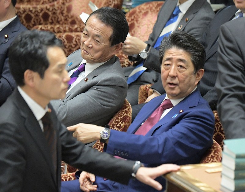 衆院予算委員会で質問を終えた立憲民主党の辻元清美幹事長代行に対する閣僚席からの自身の発言で審議が中断し混乱する中、棚橋泰文委員長に抗議する野党議員（手前）に声をかける安倍晋三首相（奥右）＝国会内で２０２０年２月１２日午後２時５０分、川田雅浩撮影