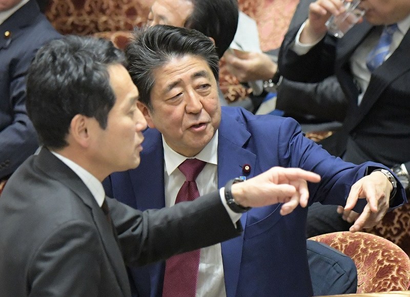 衆院予算委員会で質問を終えた立憲民主党の辻元清美幹事長代行に対する閣僚席からの自身の発言で審議が中断し混乱する中、野党議員（手前）から抗議を受ける棚橋泰文委員長に声をかける安倍晋三首相（奥）＝国会内で２０２０年２月１２日午後２時４９分、川田雅浩撮影