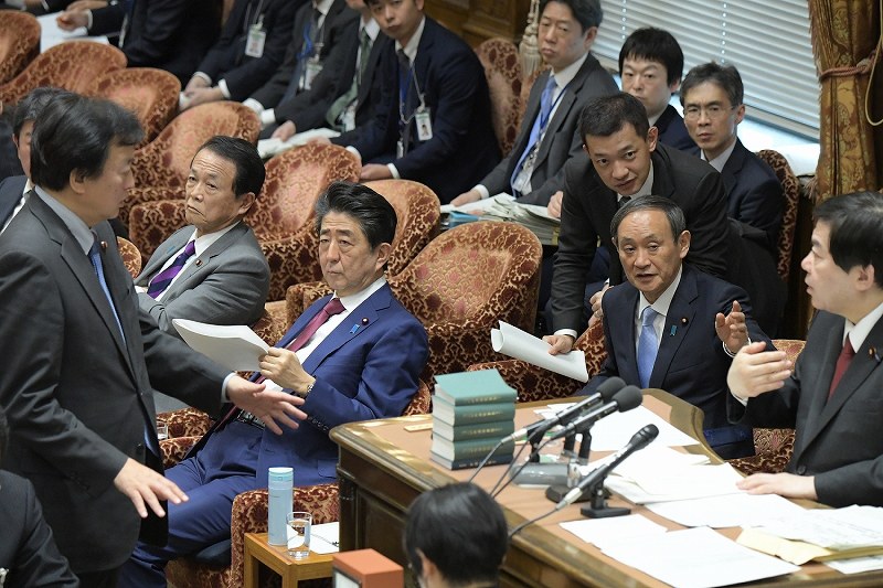 衆院予算委員会の集中審議で黒川弘務・東京高検検事長の定年延長問題について質疑が止まり、棚橋泰文委員長（右端）と野党議員（左端）の協議を待つ安倍晋三首相（前列手前）と菅義偉官房長官（後列手前）＝国会内で２０２０年２月１２日午前１１時４８分、川田雅浩撮影